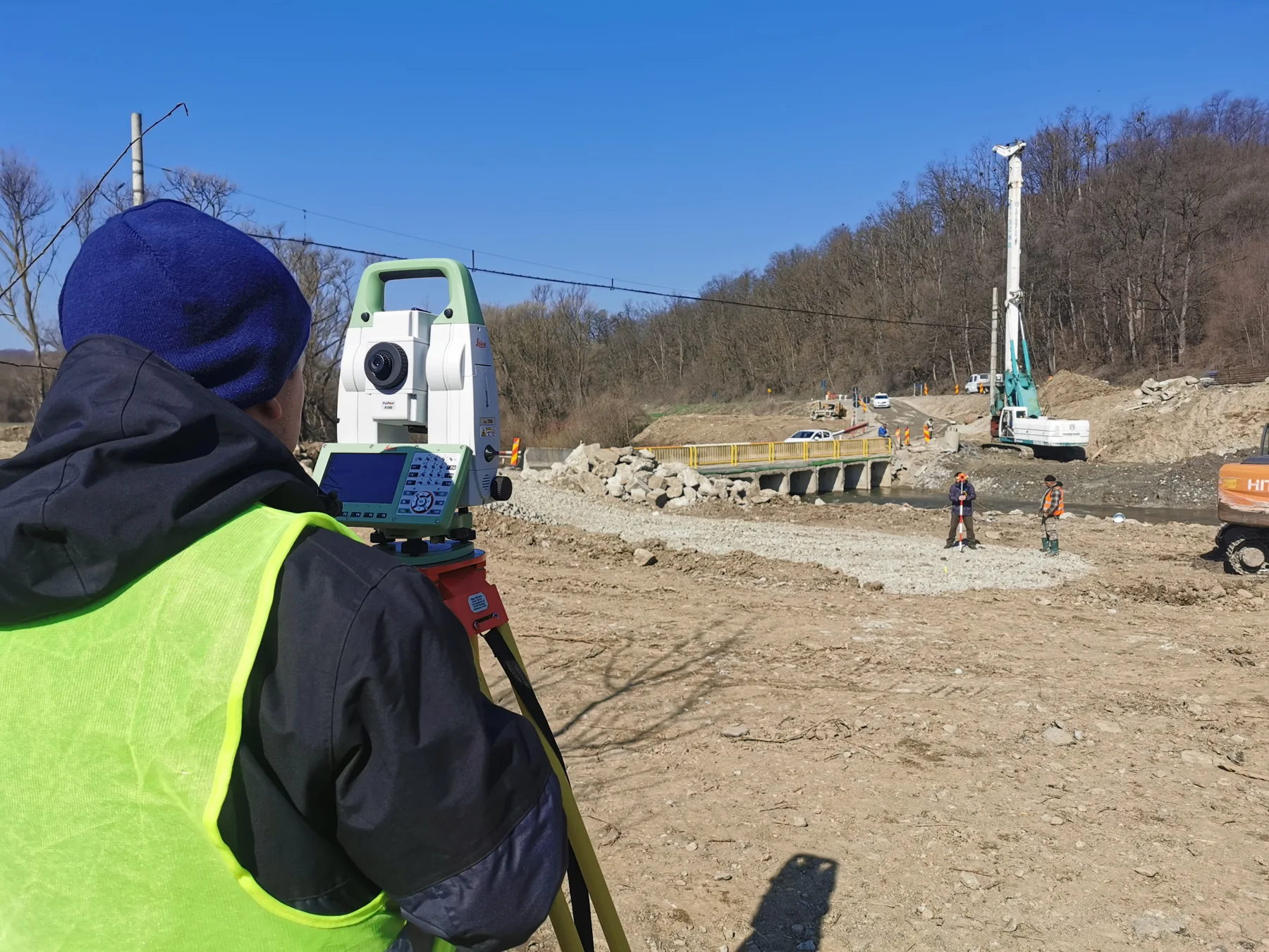 Specialist CONUS efectuează măsurători topografice pe un șantier