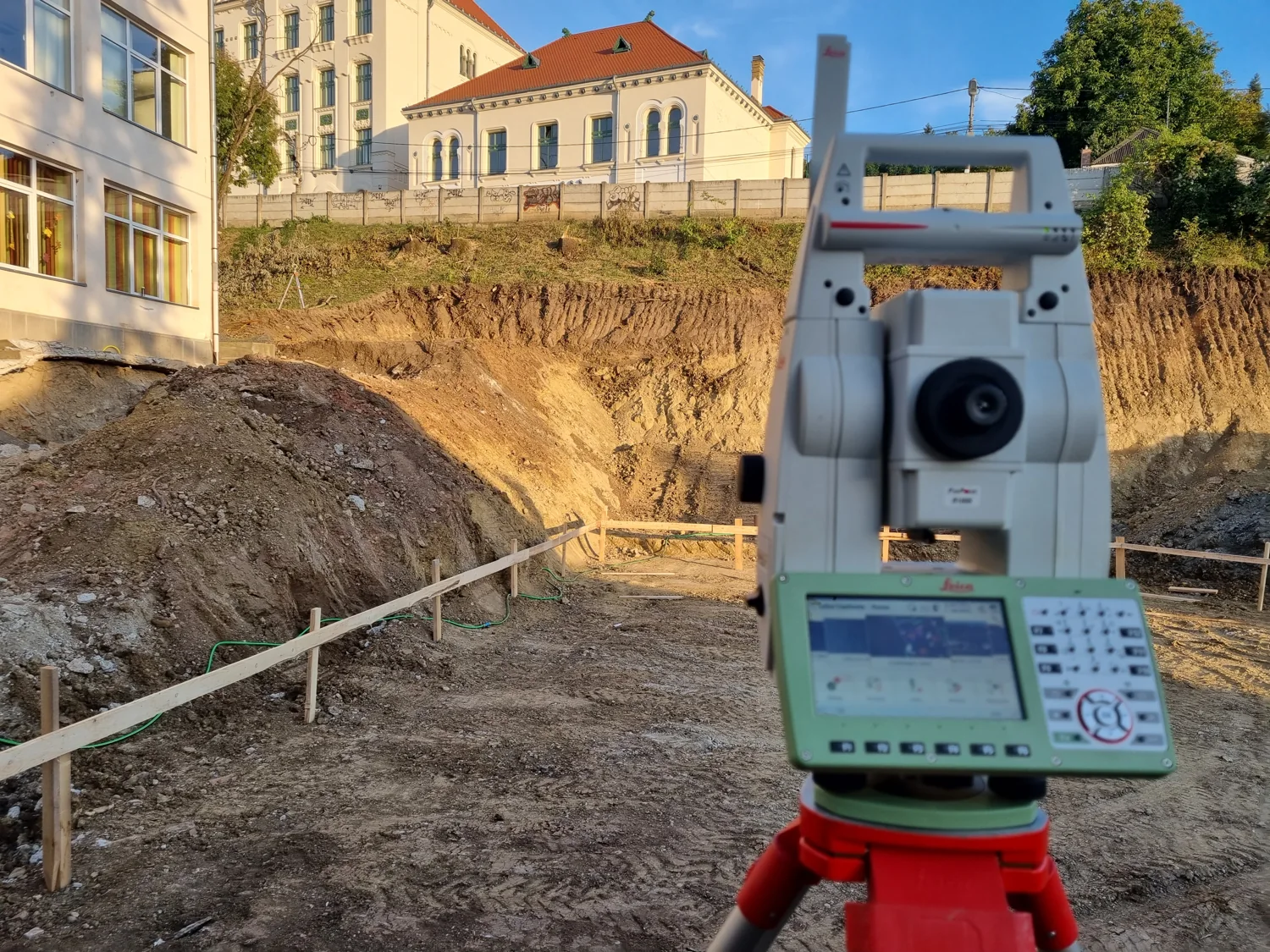 Mérőállomás egy épület melletti munkaterületen
