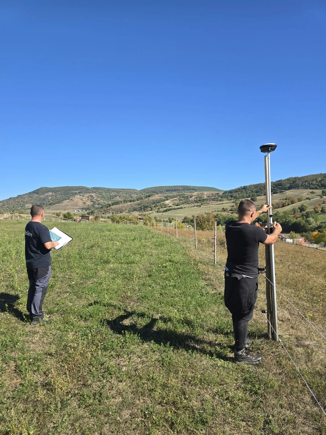 Doi colegi în timpul unei măsurători pe teren